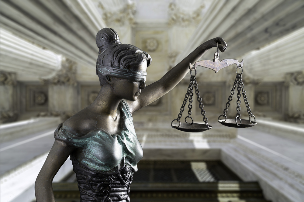 Photo of a statue of Lady Justice holding a scale.
